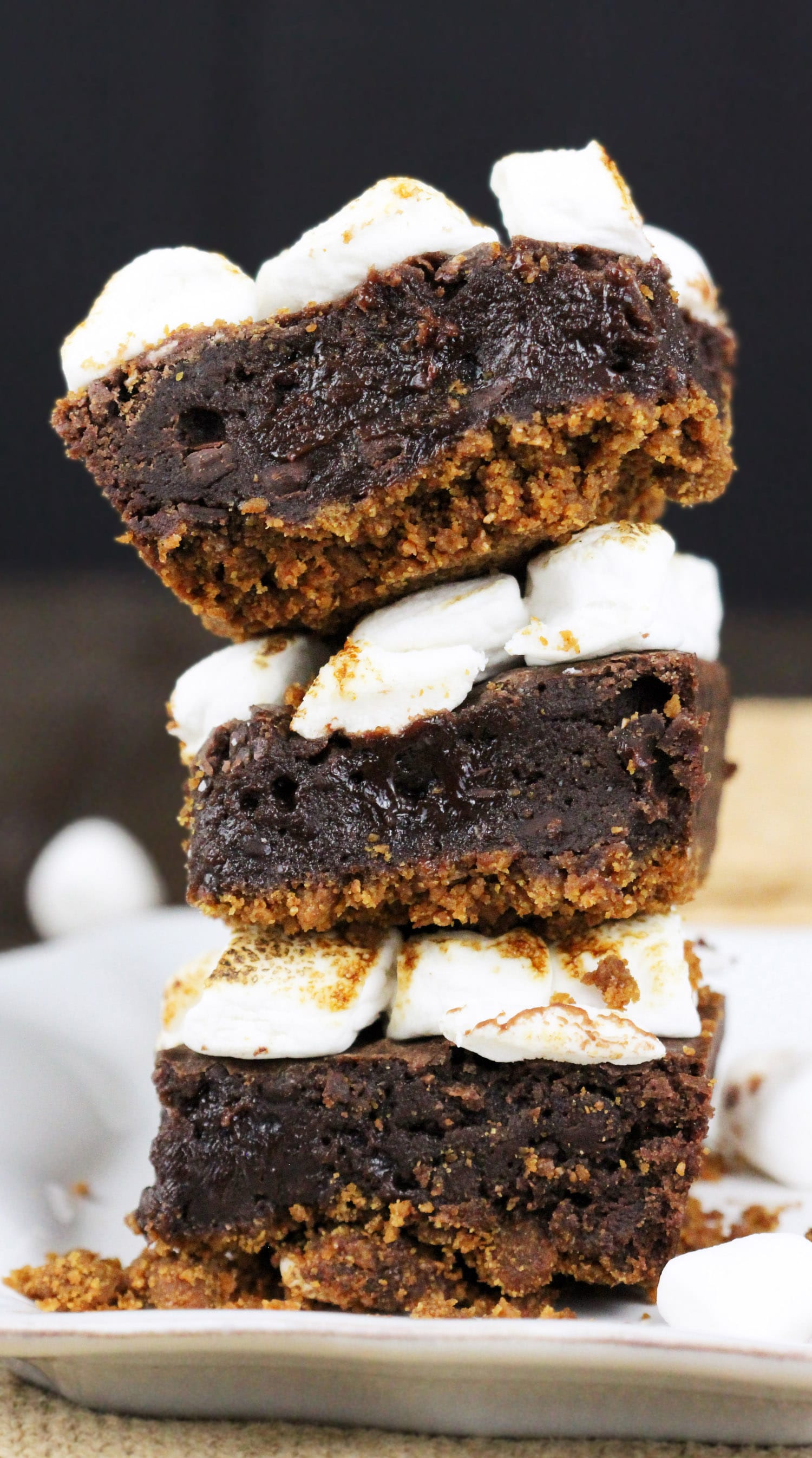 S’mores Brownies with just 6 ingredients! Satisfy your s’mores craving with these delicious brownies. Made with an actual graham cracker crust, fudge brownie filling, and a sweet marshmallow studded topping, every bite is full of salty-sweet graham cracker flavor, decadent chocolate, and toasted mallows. Healthy Dessert Recipes at the Desserts With Benefits Blog (www.DessertsWithBenefits.com)