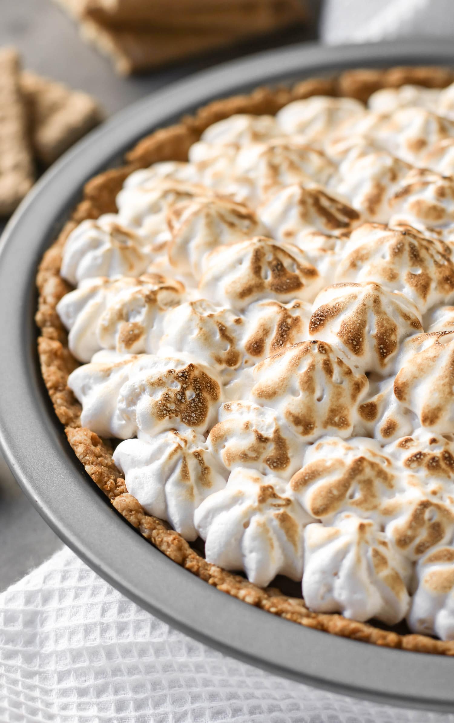 This decadent S'mores Pie has a deliciously comforting graham cracker crust, a rich and creamy chocolate filling, and a homemade marshmallow fluff topping. And it's dairy free and low in sugar! Healthy Dessert Recipes at the Desserts With Benefits Blog