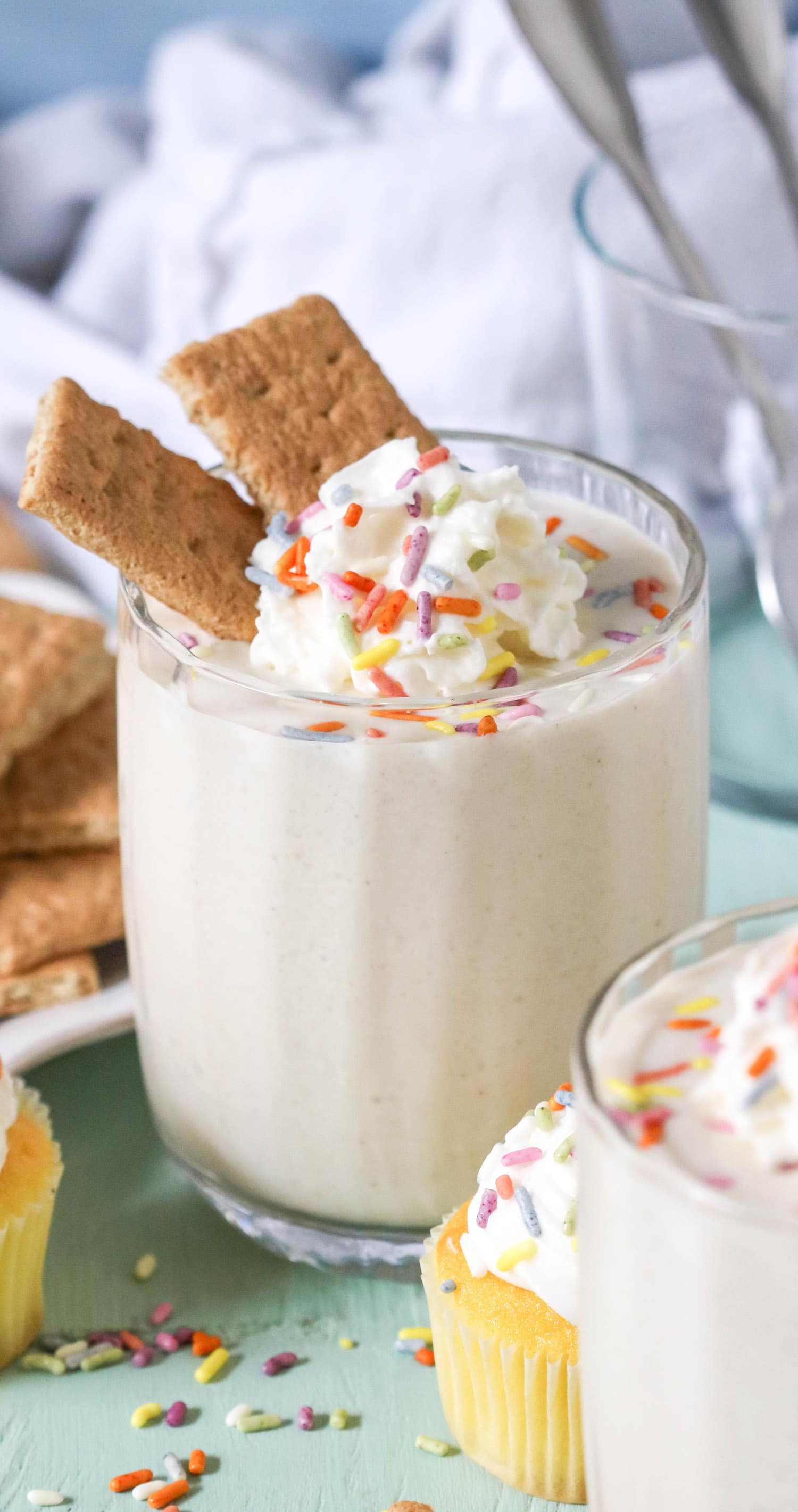 This Cake Batter Dip looks and tastes like you tossed a slice of Vanilla Cake into a blender, frosting and all!  It's ultra buttery and sweet, rich and flavorful, and smooth and creamy.  One bite and you'd never guess it's healthy, sugar free, low fat, high protein, and gluten free too.  Serve up this deliciousness alongside some Graham Crackers, Animal Crackers, fresh strawberries, or spoons alone.