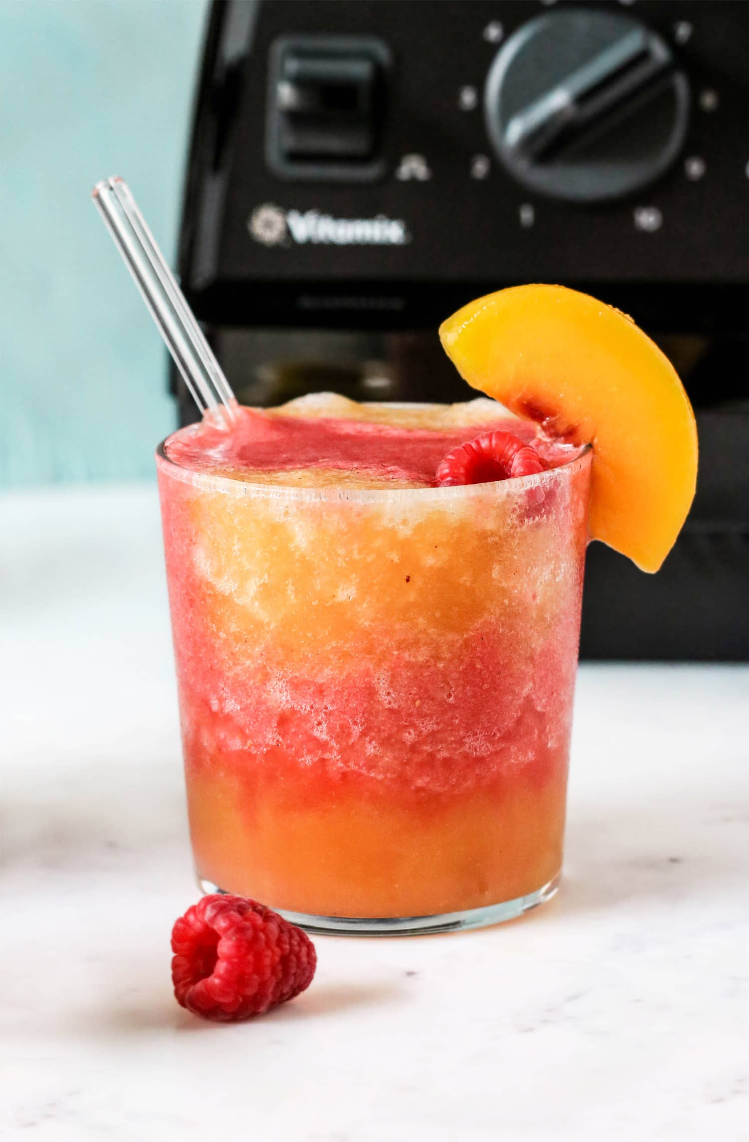 This Peach Melba Frosé is full of sweet peaches, tart raspberries, and good ol' pinot noir rosé (and no sugar added)! You only 5 ingredients to make this easy frose recipe. This is the perfect frosty, boozy treat!