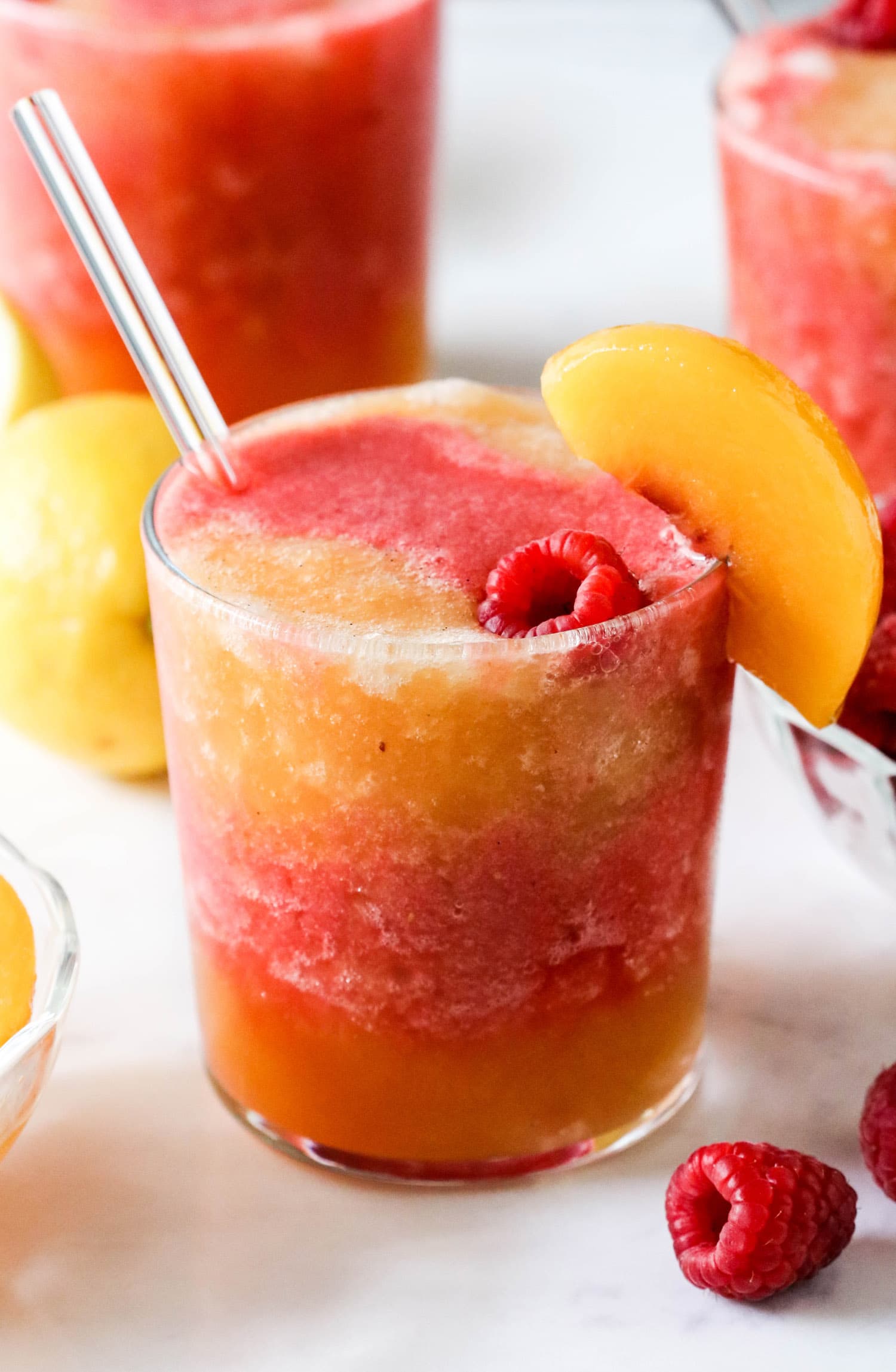 This Peach Melba Frosé is full of sweet peaches, tart raspberries, and good ol' pinot noir rosé (and no sugar added)! You only 5 ingredients to make this easy frose recipe. This is the perfect frosty, boozy treat!