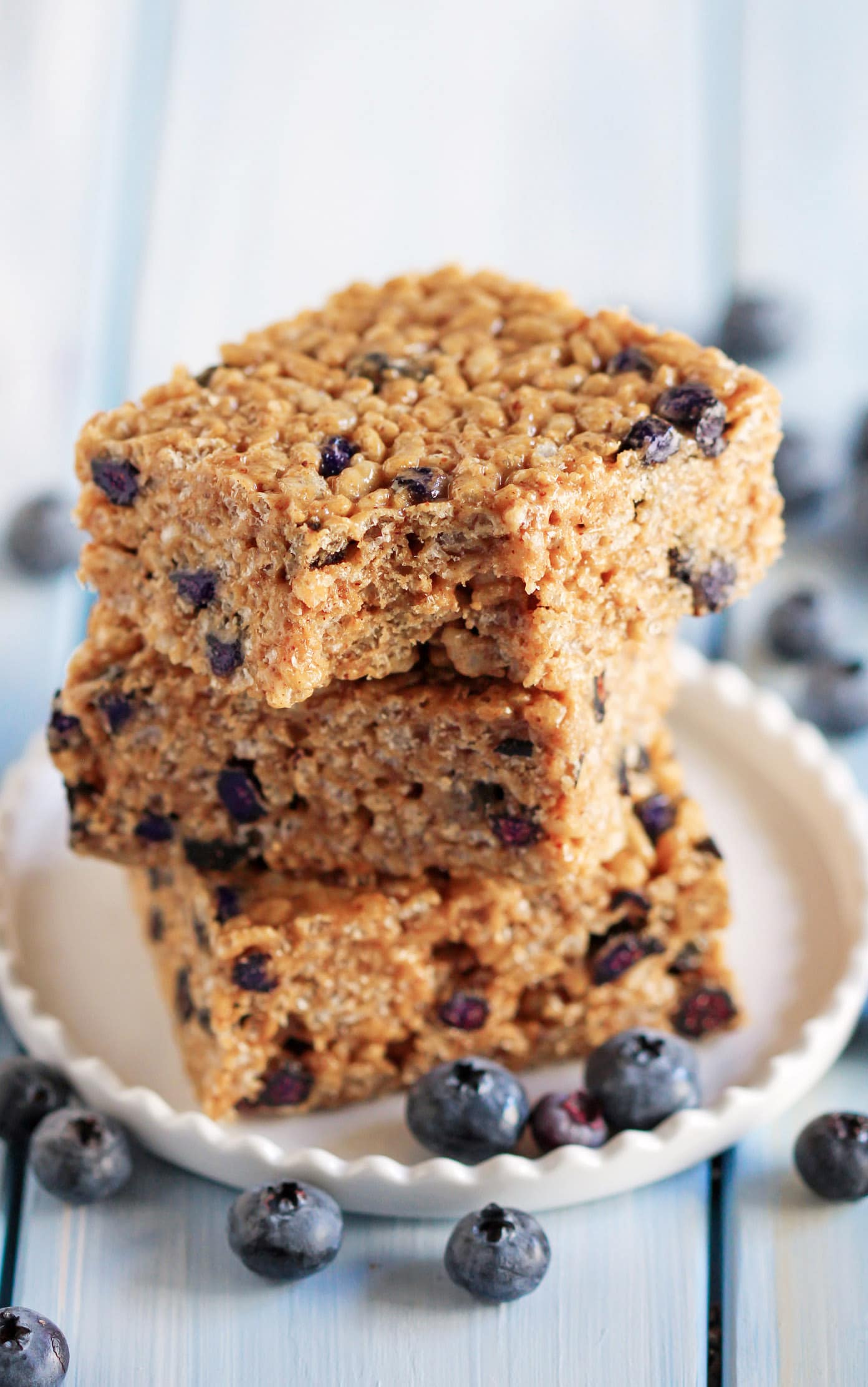 These Blueberry Bliss Krispy Treats are secretly healthy -- made with whole grain brown rice cereal, low glycemic raw honey, delicious almond butter, and a sprinkling of protein powder. It's crispy and chewy, but without the butter and sugary, high-fructose corn-syrup-laden marshmallows.