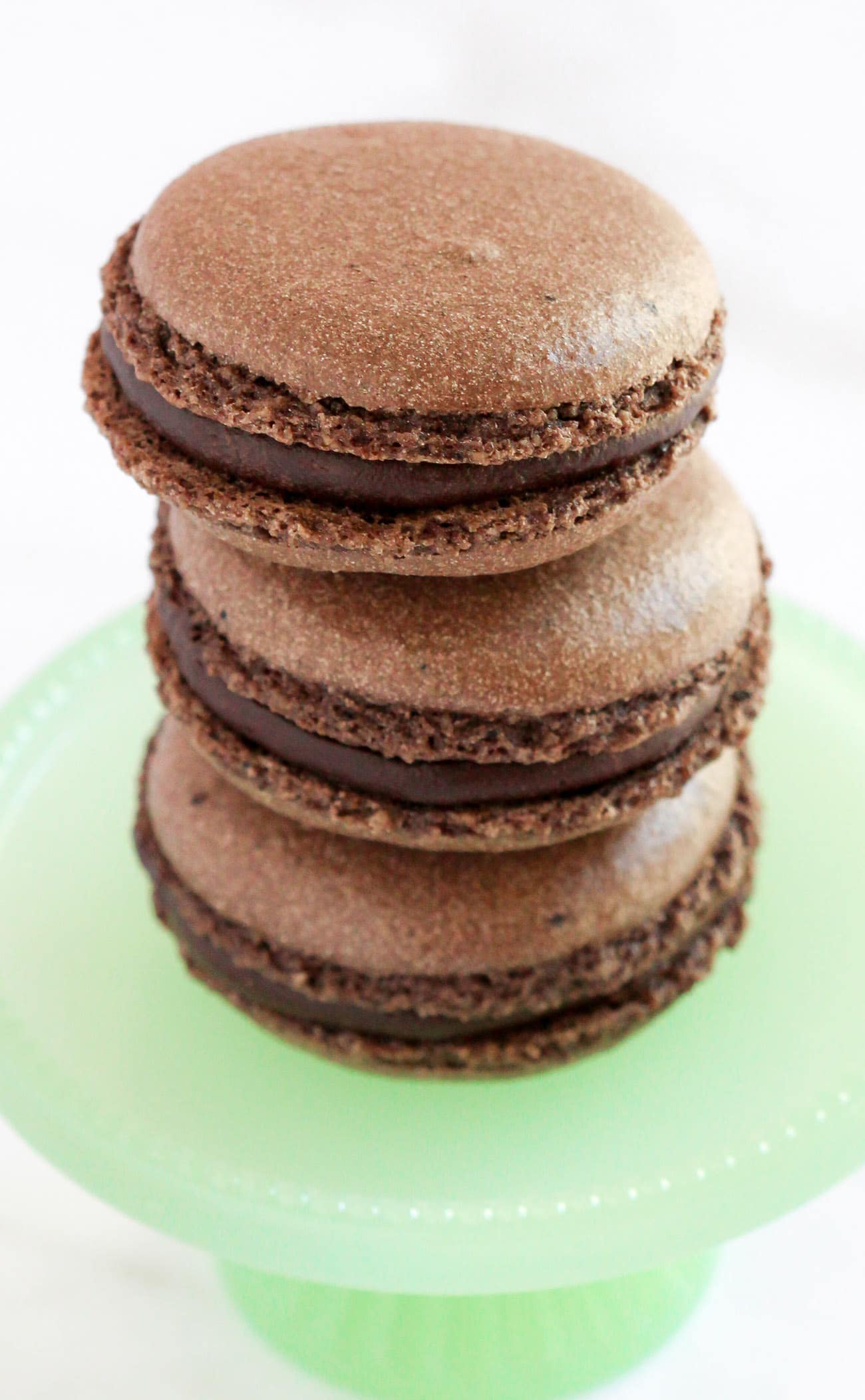 These Gluten Free Chocolate French Macarons are perfectly sweet and chewy, thanks to the almond meal and dark cocoa powder! Made without the bleached white sugar and artificial flavors, yet you'd never know! #chocolate #frenchmacarons #macarons #glutenfree #glutenfreemacarons #valentinesday